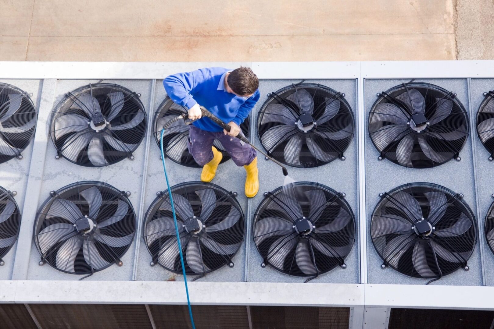 A man is cleaning the air conditioning unit.